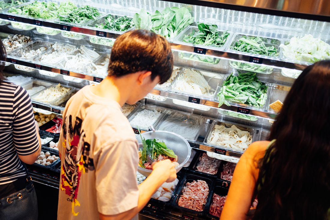 Diners picking greens from the ingredient fridge